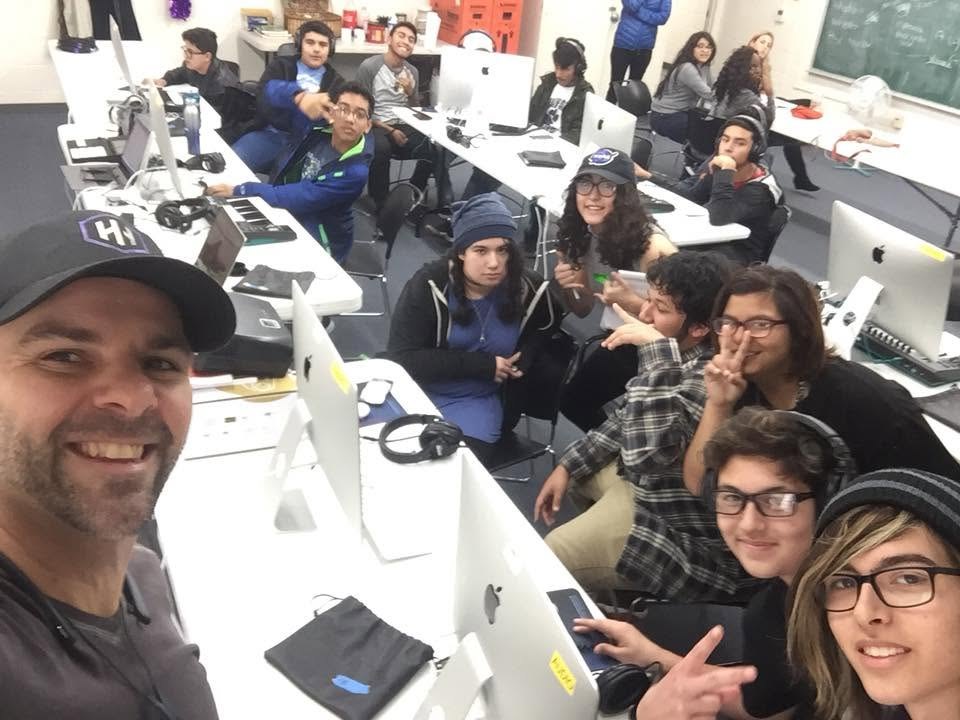Nathan Adam taking a photo with GRAMMY Camp students crowded around a studio console