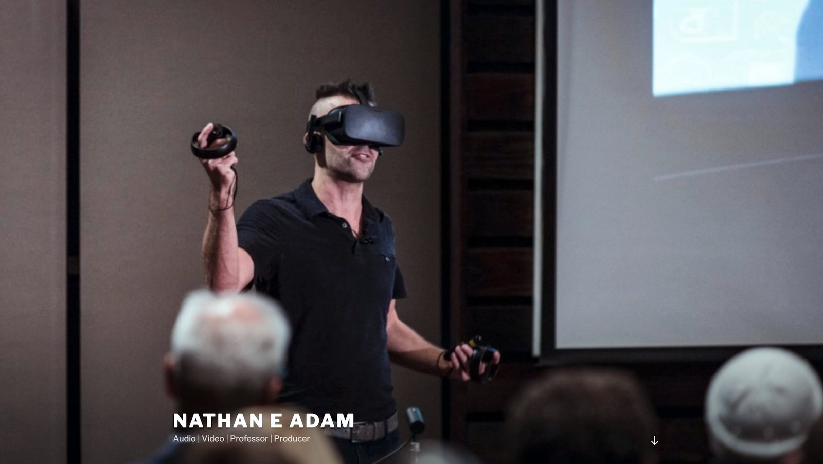 Nathan Adam onstage at TEDxNashville wearing a VR headset in front of an audience